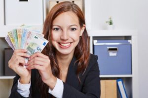 donna che sorride con in mano tante banconote di euro