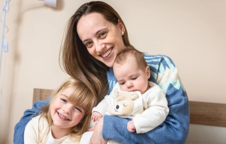 donna che abbraccia due bambini piccoli