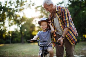nonno con nipote in con casco in bicicletta