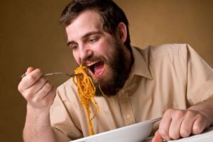 Uomo che mangia un piatto di pasta